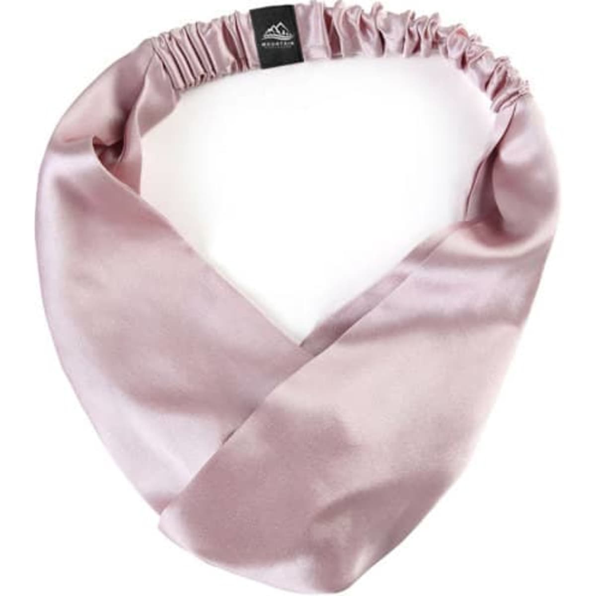 A 100% mulberry silk headband in a soft pink shade, featuring an elasticated design and a logo.