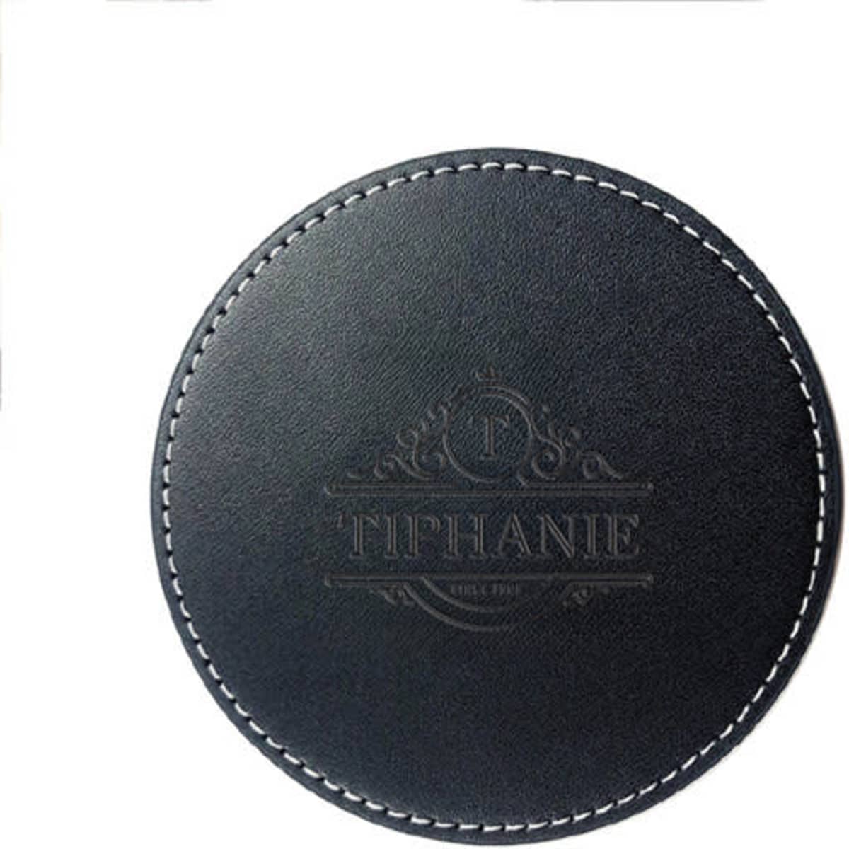 A round black PU leather coaster featuring a decorative embossed design and contrasting white stitching.