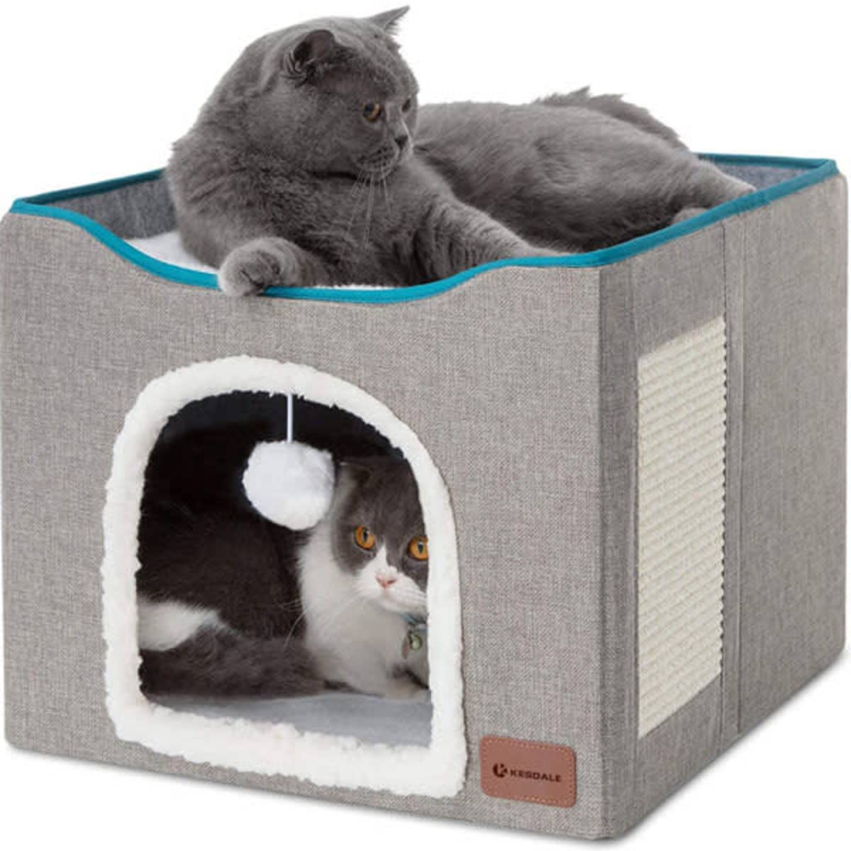 A grey foldable cat cube house with a plush interior, featuring two cats—one inside and one on top.