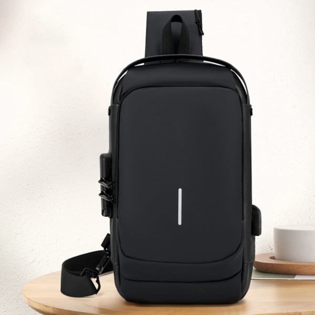 A black anti-theft sling chest bag with a sleek design, featuring a strap and a compartment for storage.