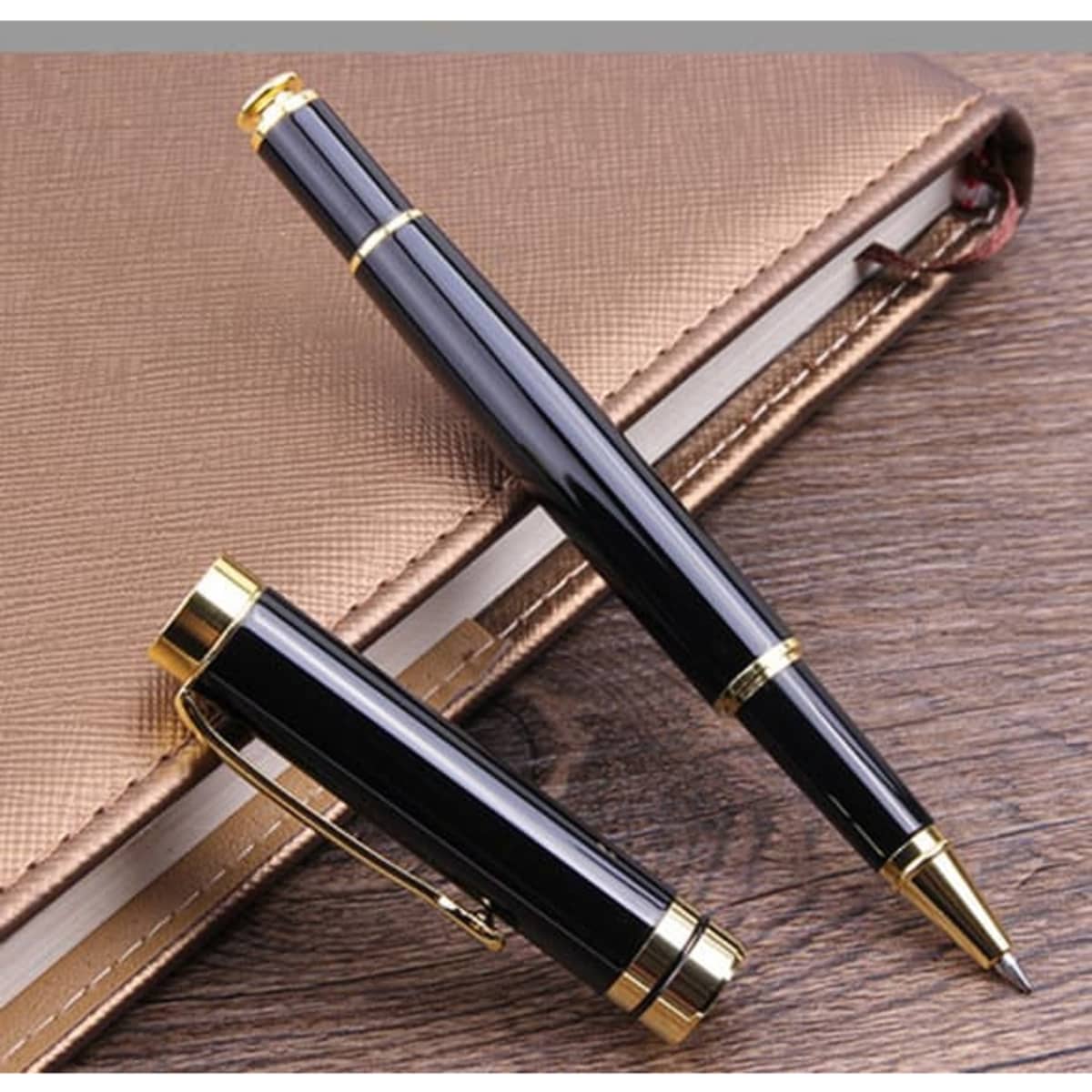 A black rollerball pen with gold accents, positioned alongside its cap, resting on a brown surface.