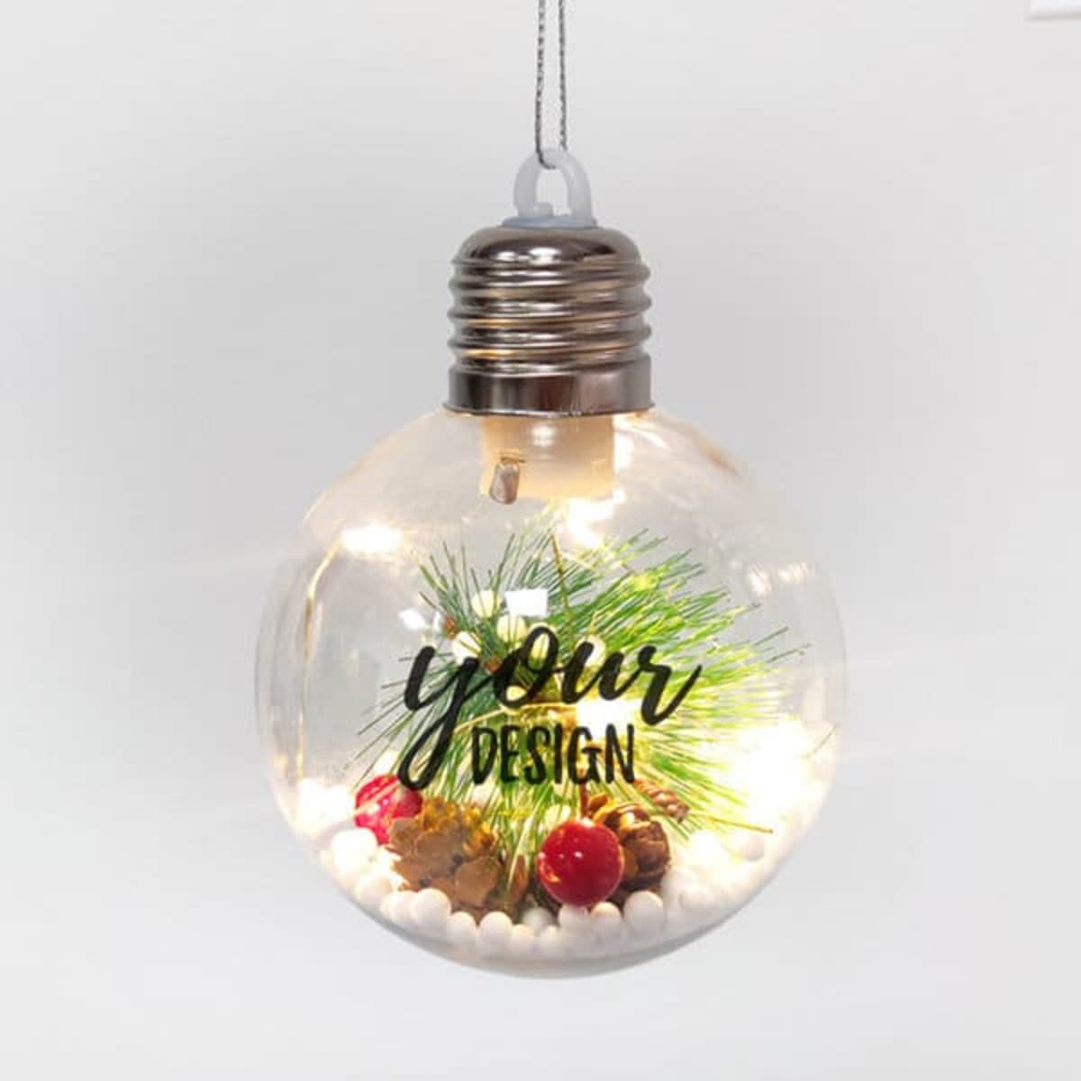 A clear LED light Christmas ornament ball filled with decorative elements, featuring a silver cap and cord for hanging.