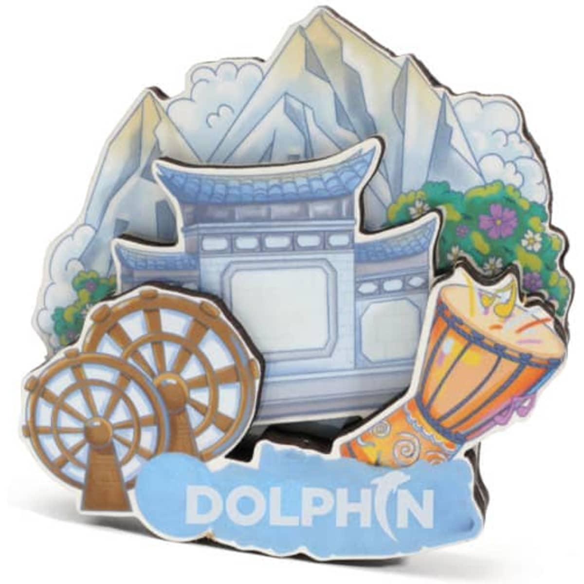 A colourful 3D refrigerator magnet featuring mountains, a structure, and decorative elements like wheels and a drum.