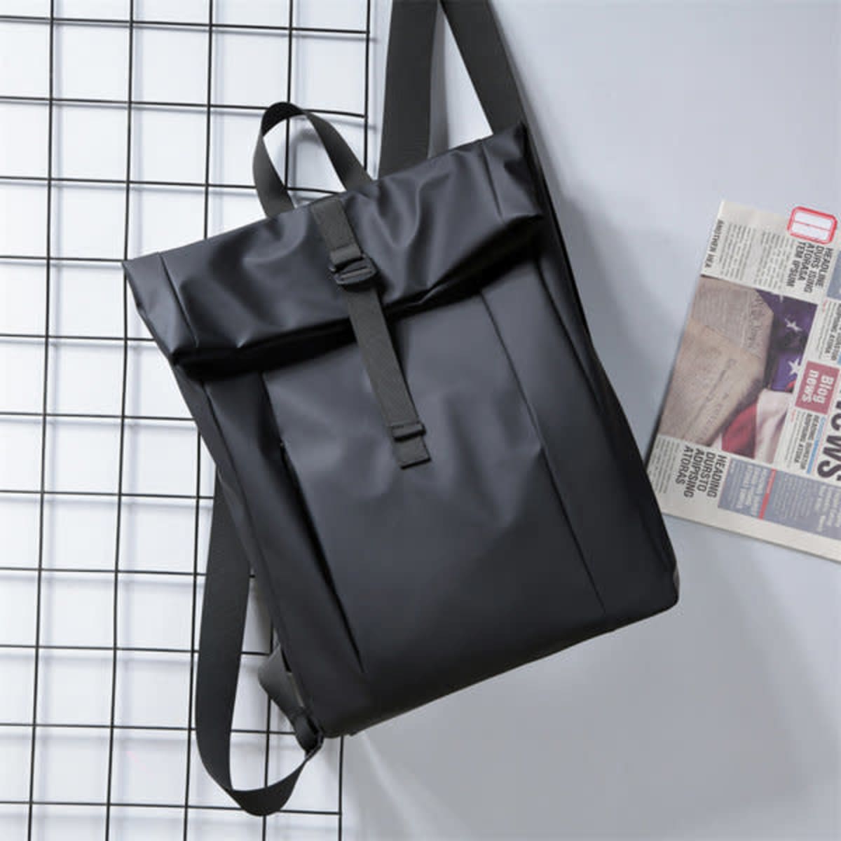 A black expandable casual laptop daypack with adjustable straps and a flap opening, featuring a logo.