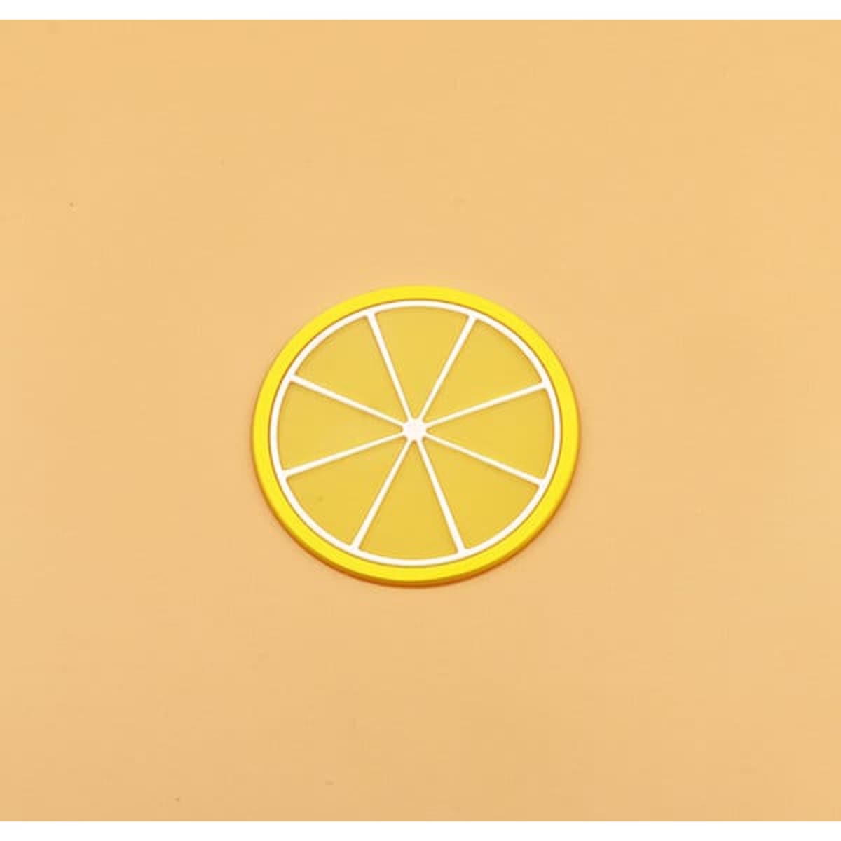 A yellow silicone coaster shaped like a lemon slice, featuring white detailing and a circular design.