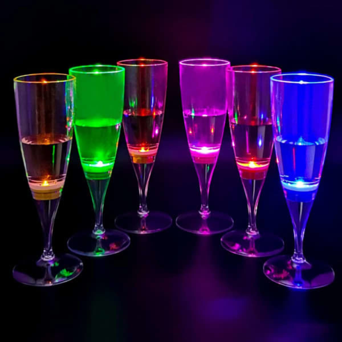 A set of seven LED light up champagne glasses in vibrant green, pink, and blue, glowing against a dark background.