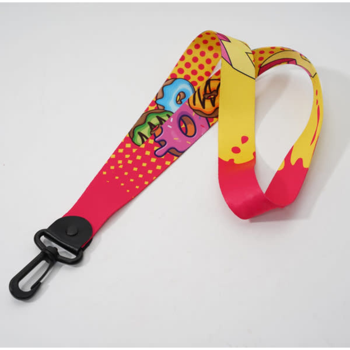 A vibrant neck strap key chain holder in pink and yellow with graphic designs and a clip attachment.