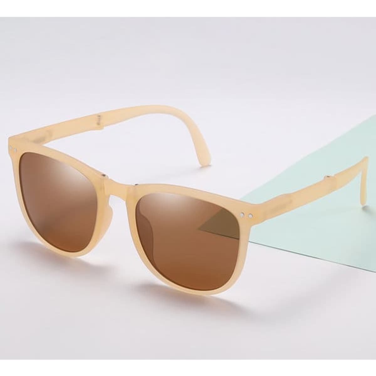 A pair of beige polarized folding sunglasses with brown lenses, displayed on a light background.