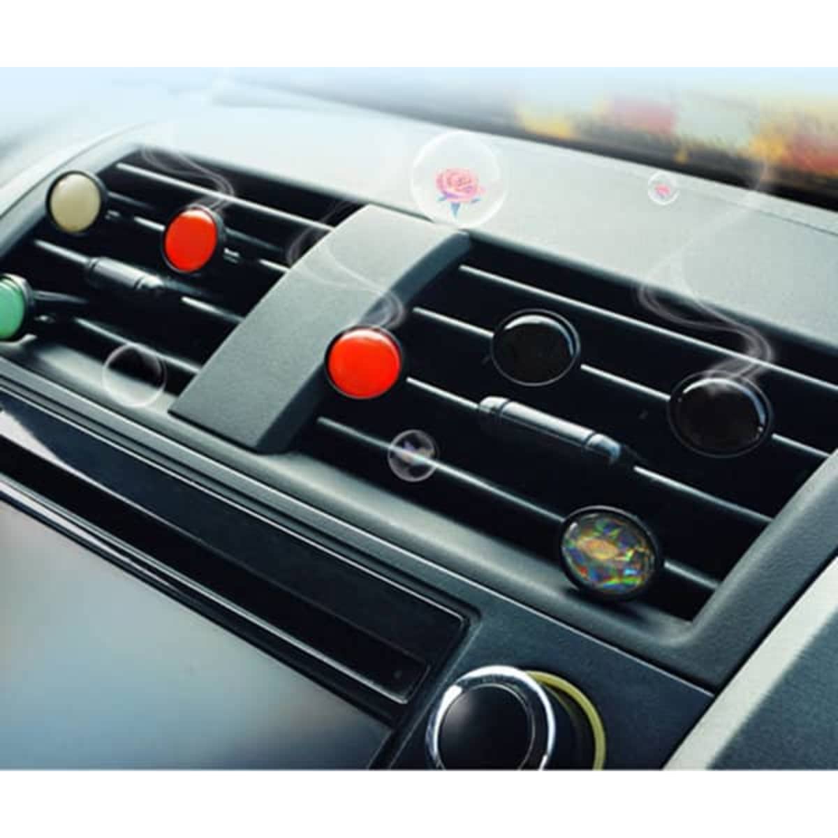 A customised car air freshener vent clip in various colours is displayed within a car's dashboard vents.