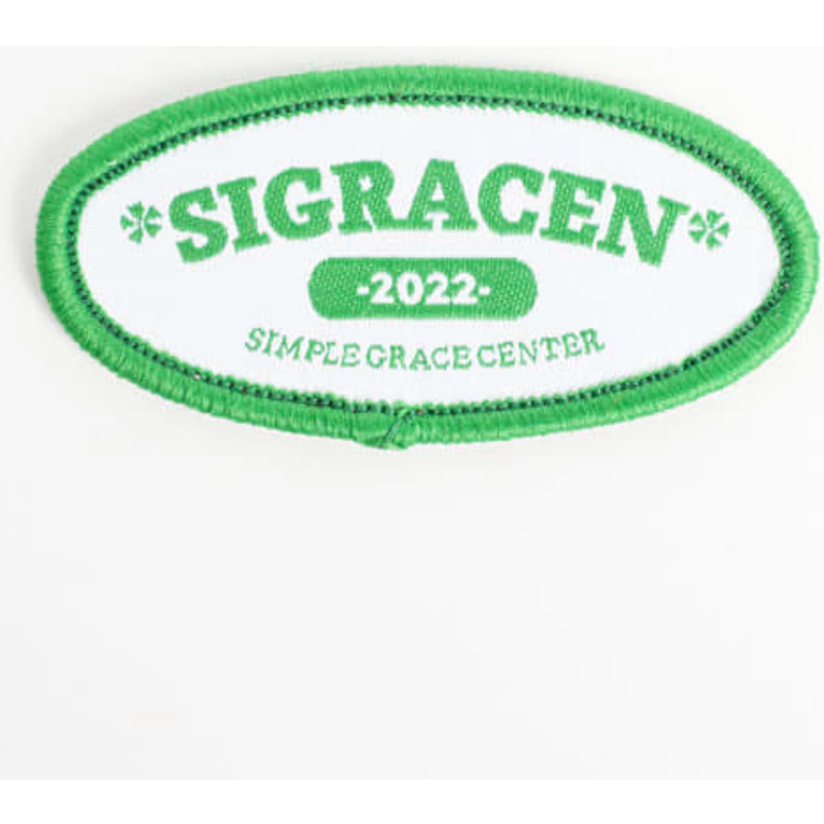 A green and white embroidered patch featuring the text “SIGRACEN 2022” and “SIMPLEGRACECENTER”.