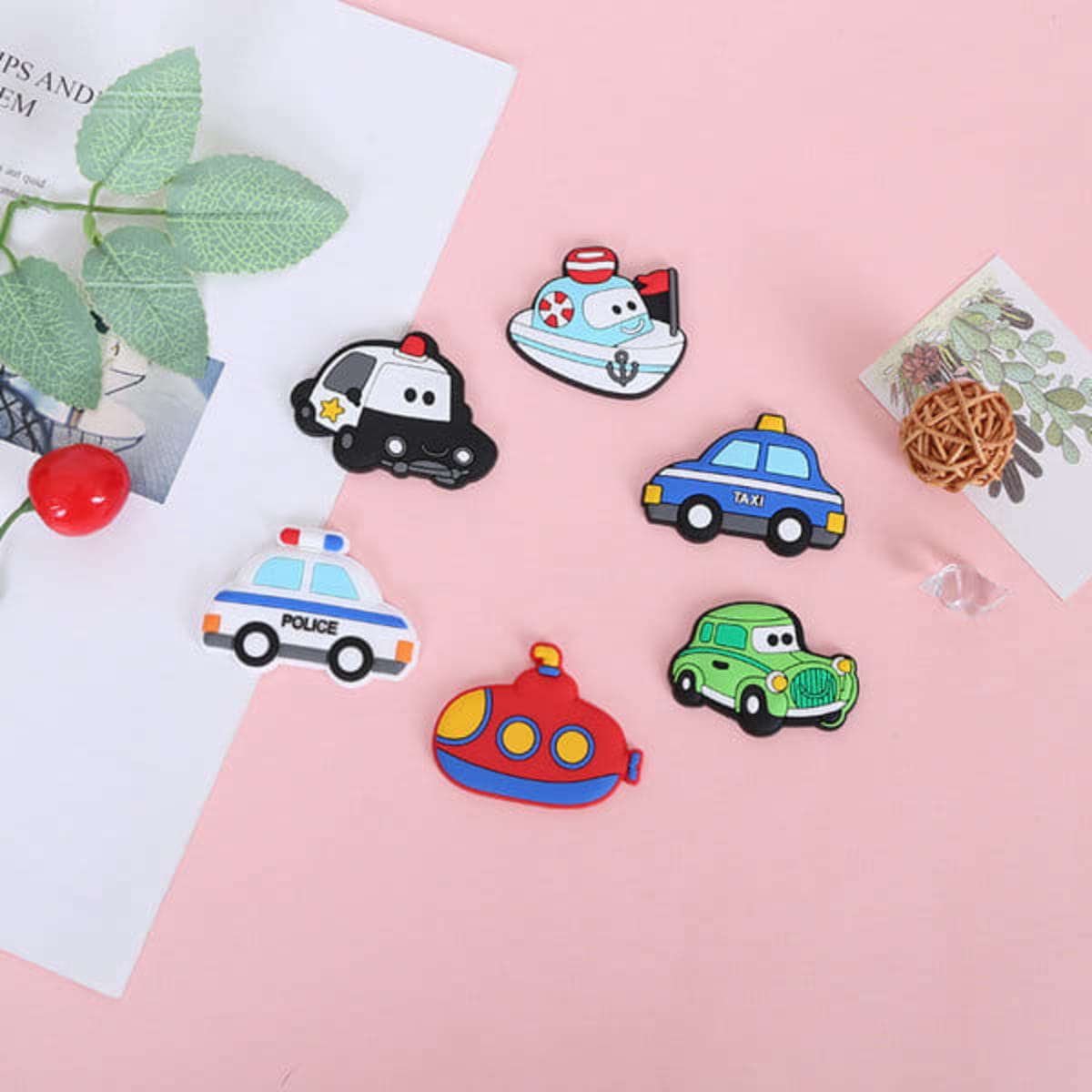 A set of colourful personalised refrigerator magnets featuring various vehicle designs, including police cars, a taxi, and a submarine.