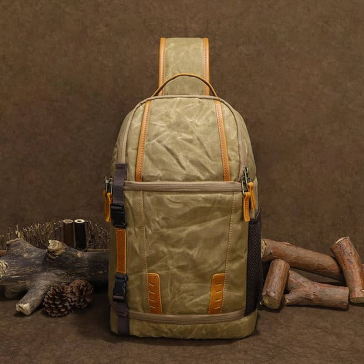 A waterproof sling camera backpack in olive green and brown, featuring multiple compartments and a logo.