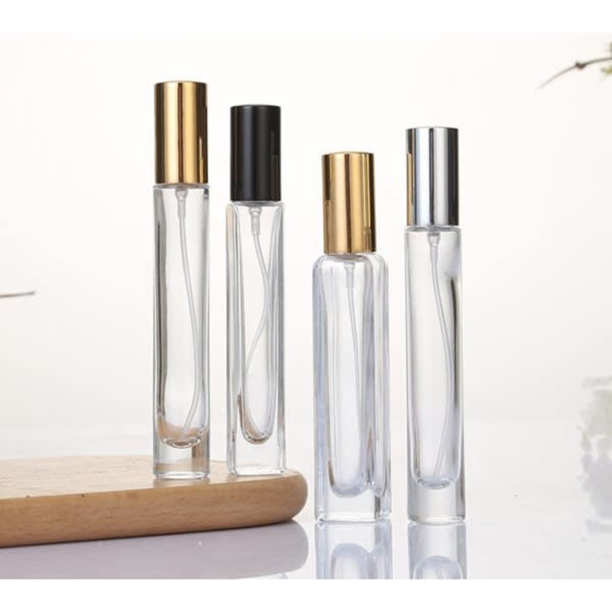 A set of four portable perfume atomizer bottles in clear glass with gold, black, and silver caps.