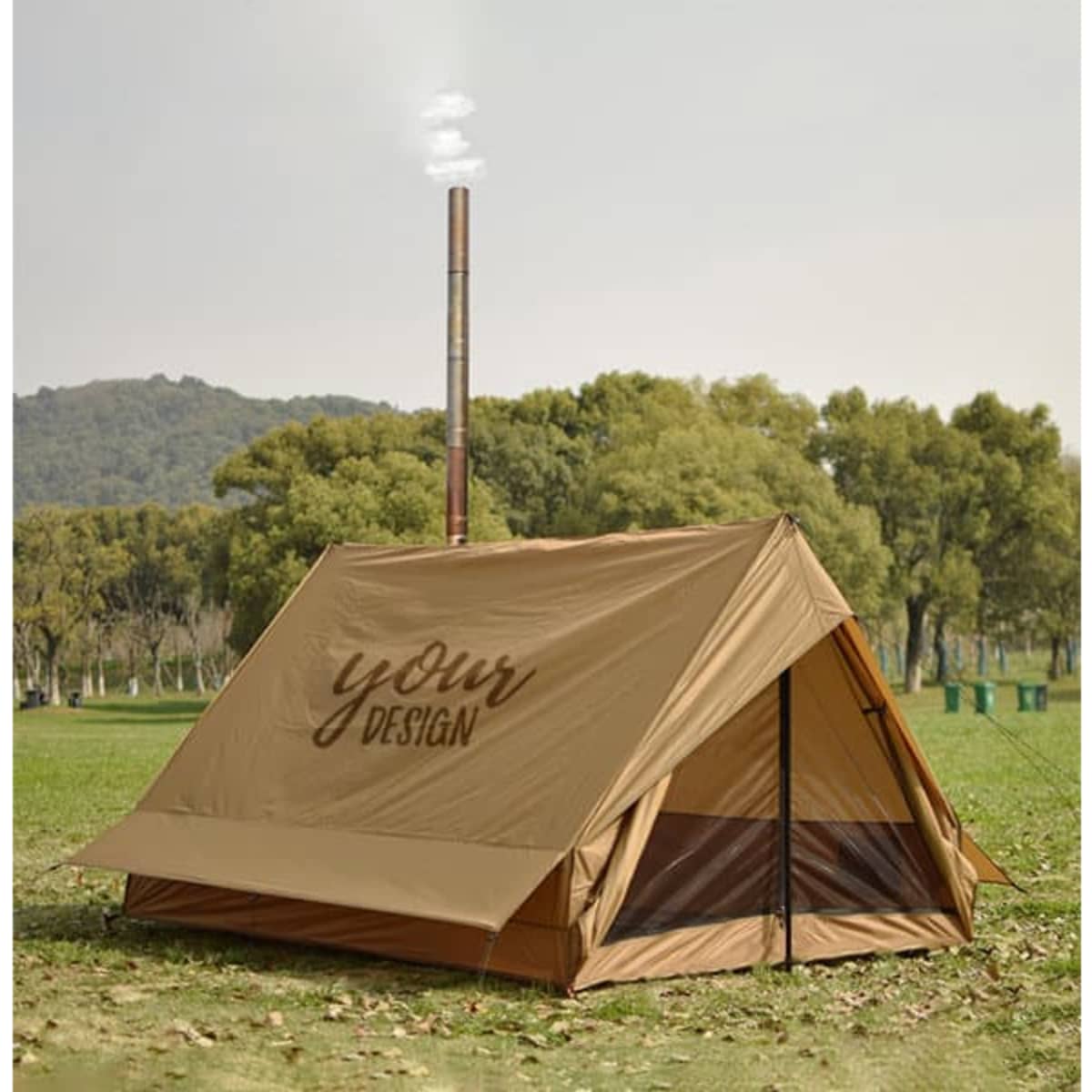 A tan camping wall tent featuring a stove jack, set in a grassy outdoor area with trees in the background.