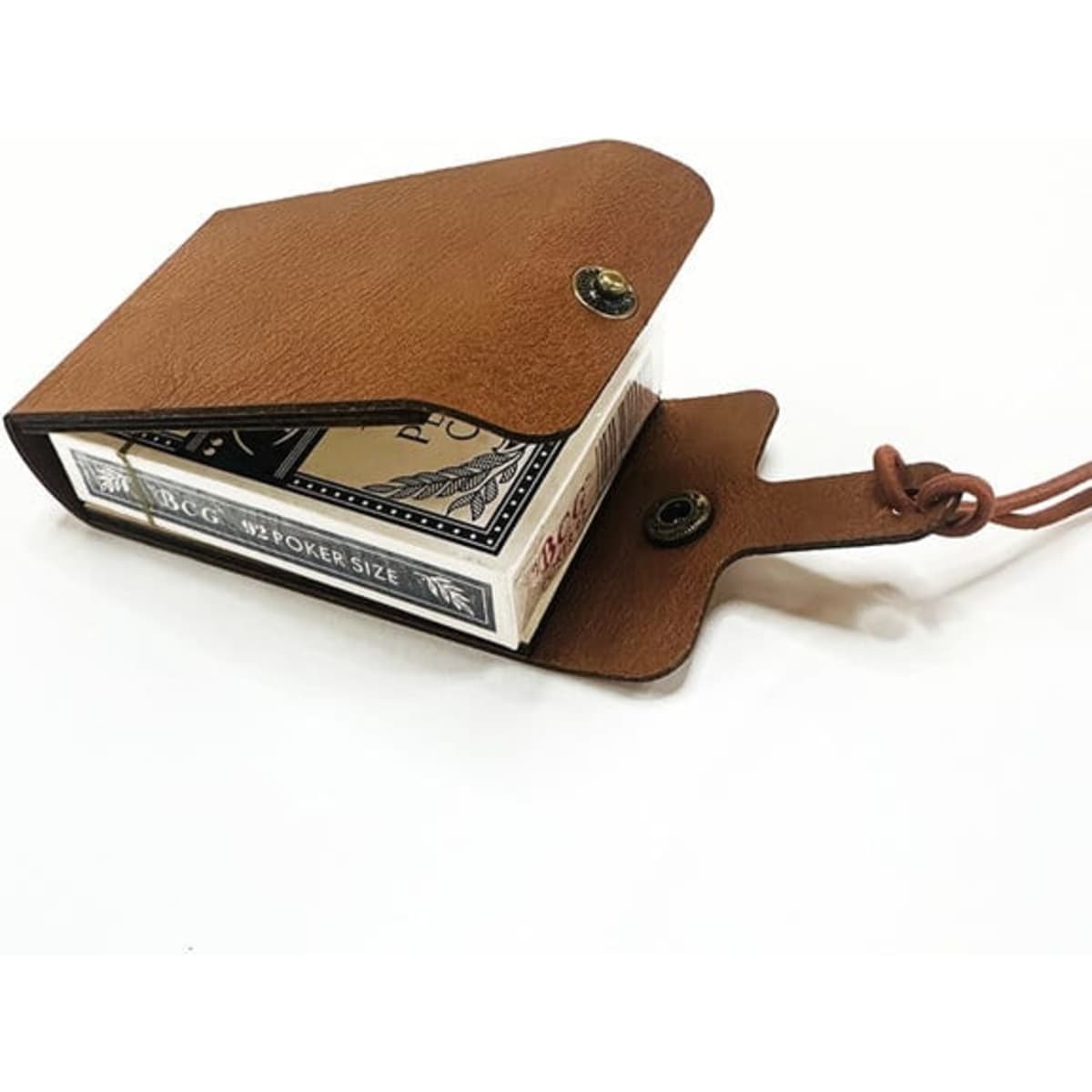 A brown leather travel cribbage board with a button closure, holding a deck of playing cards inside.