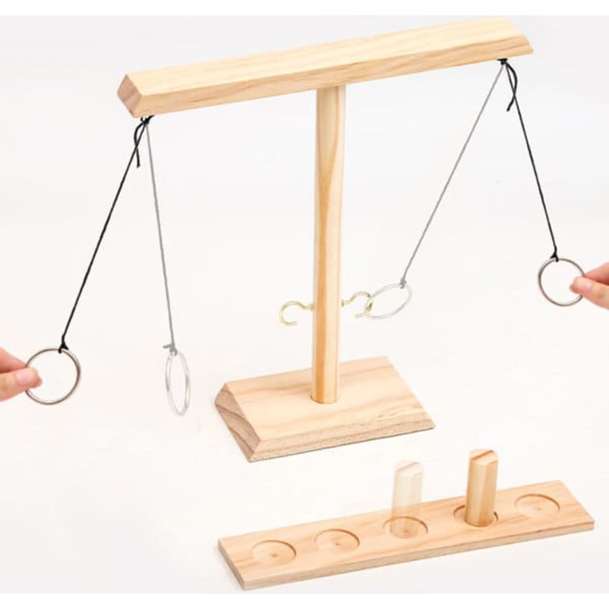 A wooden Hook and Ring Game featuring a stand with rings on strings and a base with pegs, in natural wood colour.
