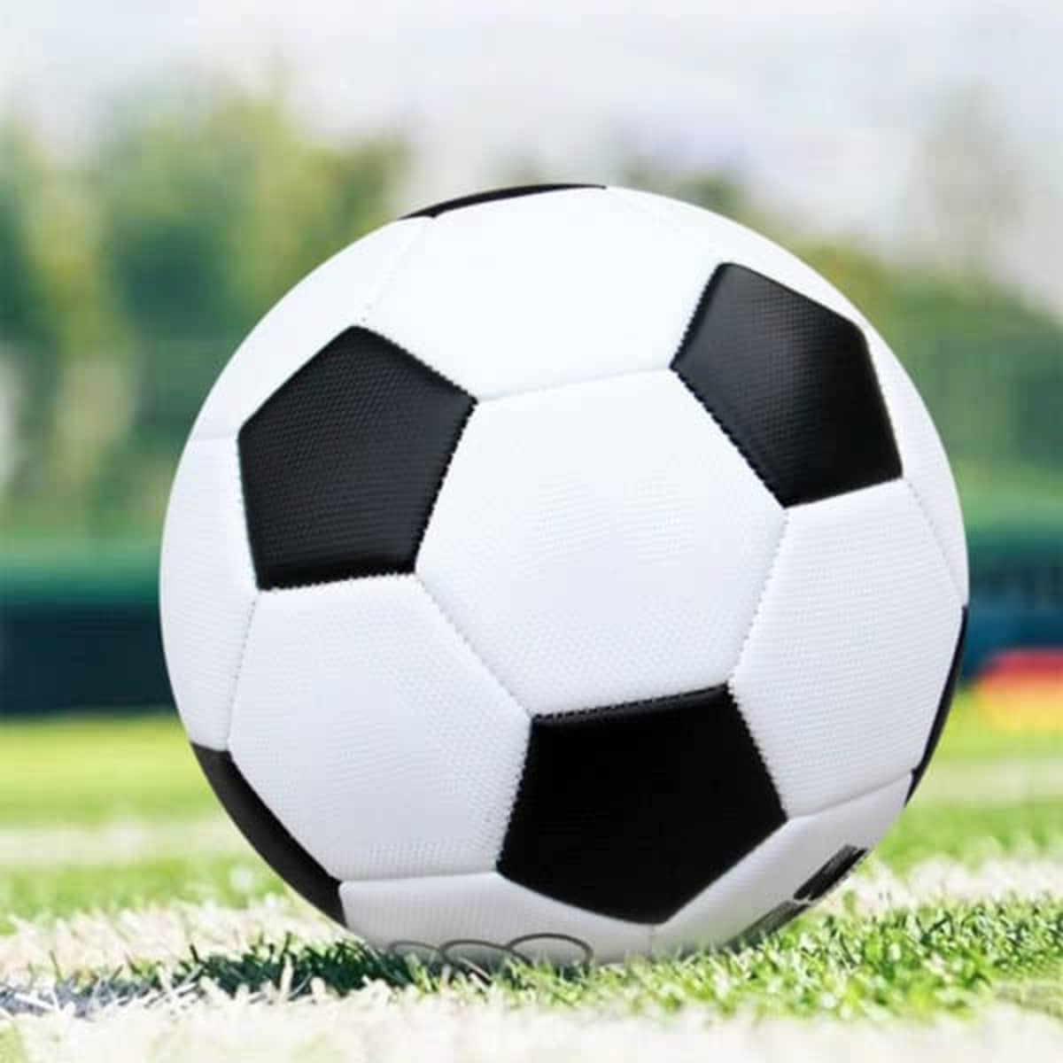 A custom soccer ball featuring a classic black and white design on a grassy field.