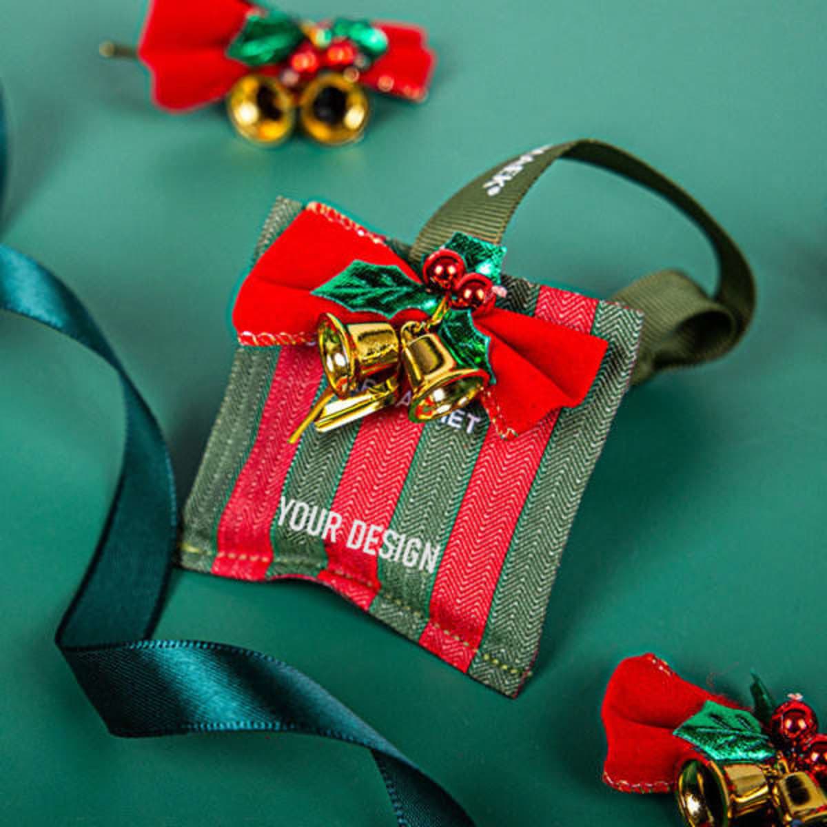 Christmas ornament sachets in red and green with bells and ribbon accents, featuring a logo on one side.