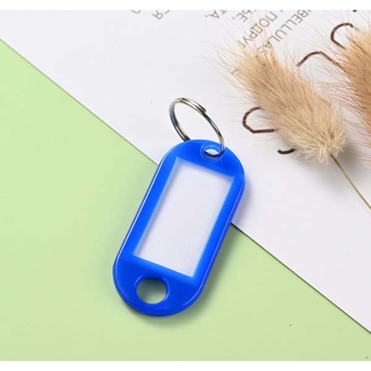 A blue custom key tag with a tang ring, featuring a clear central section for personalisation.