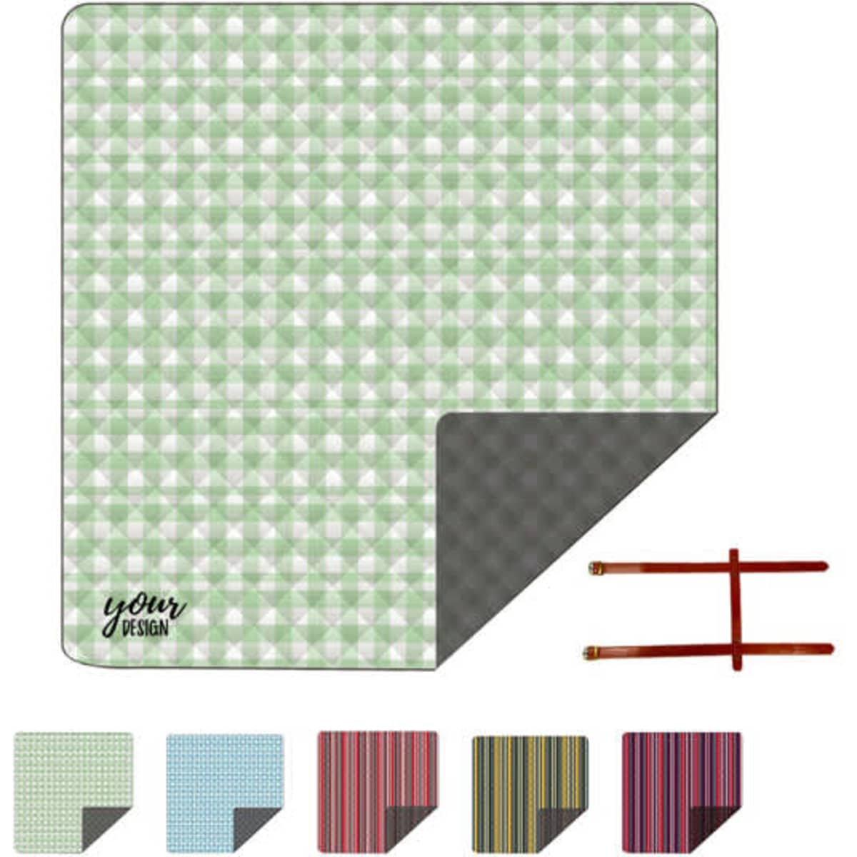A green and white patterned picnic blanket with a grey underside and brown leather straps for easy carrying.