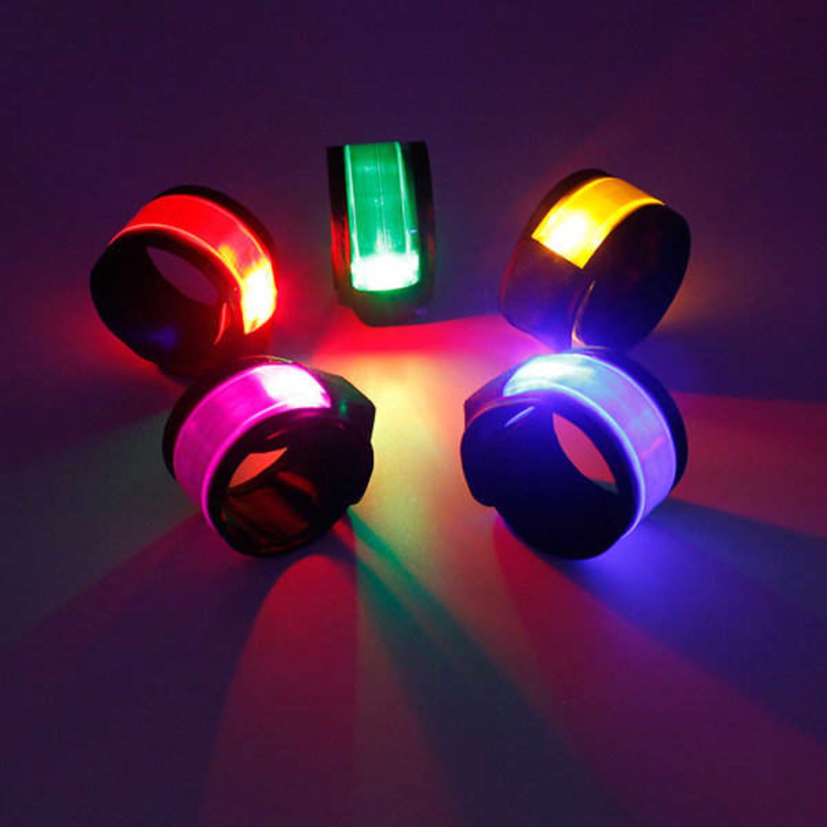 Brightly coloured slap bracelets with LED lights, displayed against a dark background. Various colours are visible.