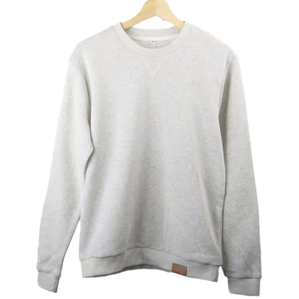 A light grey crew neck sweatshirt hanging on a wooden hanger, featuring a small logo on the hem.