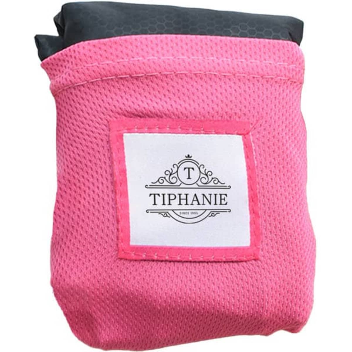 A folded pink picnic blanket with a black top, featuring a logo on the side.