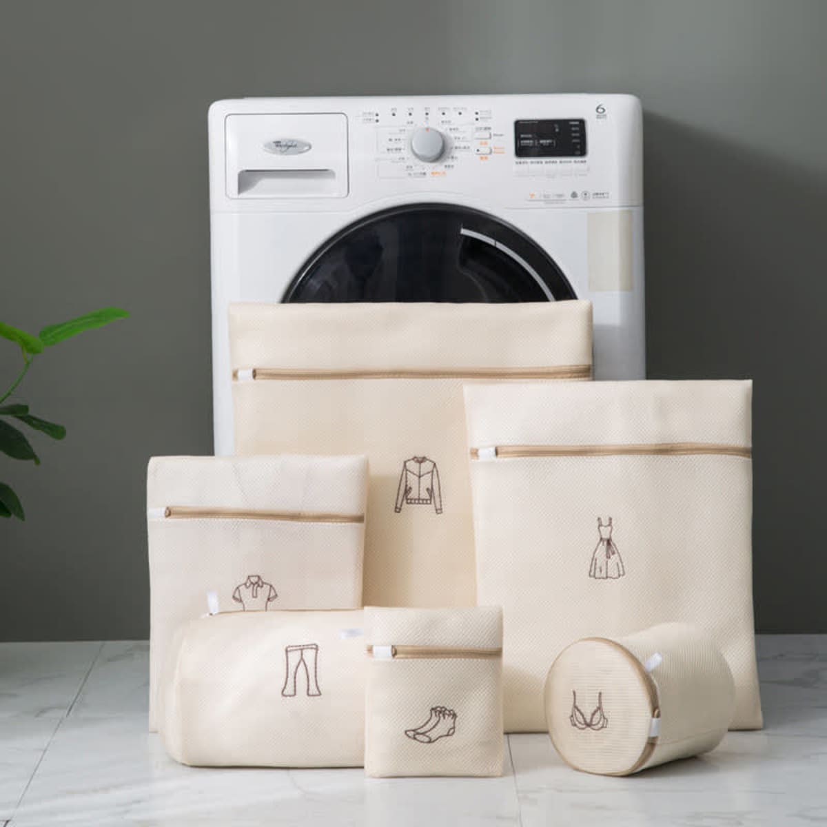A set of six double-layer mesh laundry bags in cream, featuring various sizes and detailed illustrations on each bag.