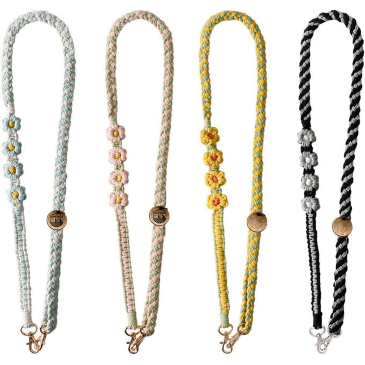 A collection of four handmade macrame lanyards with clips, featuring pastel colours and floral designs.
