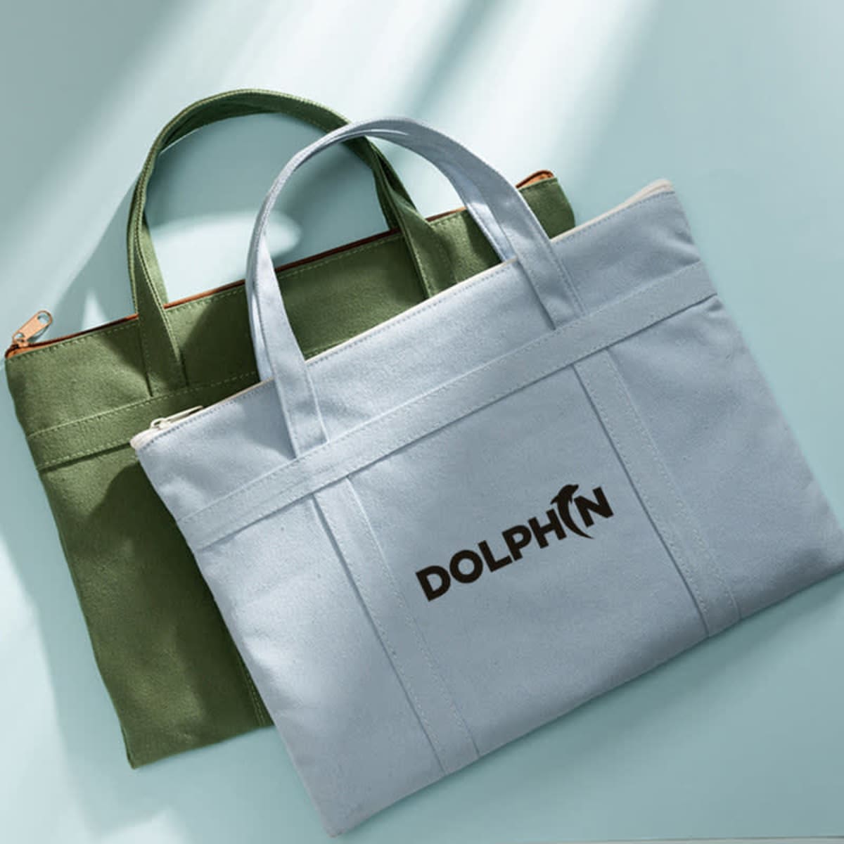 A green and light blue multilayered canvas file bag with handles, featuring a logo on the front.