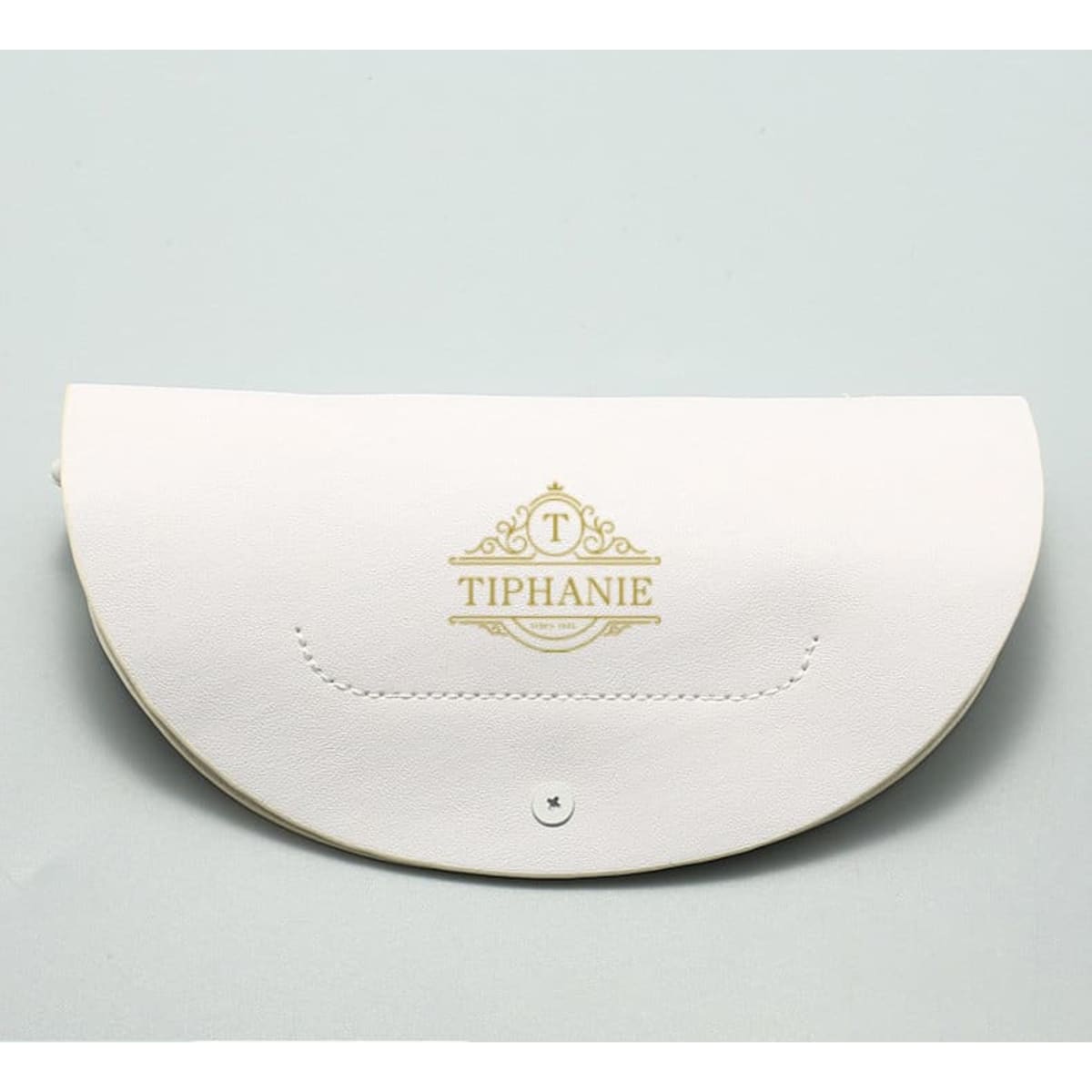 A white glasses case with a gold logo and a snap closure. The case features a curved, sleek design.