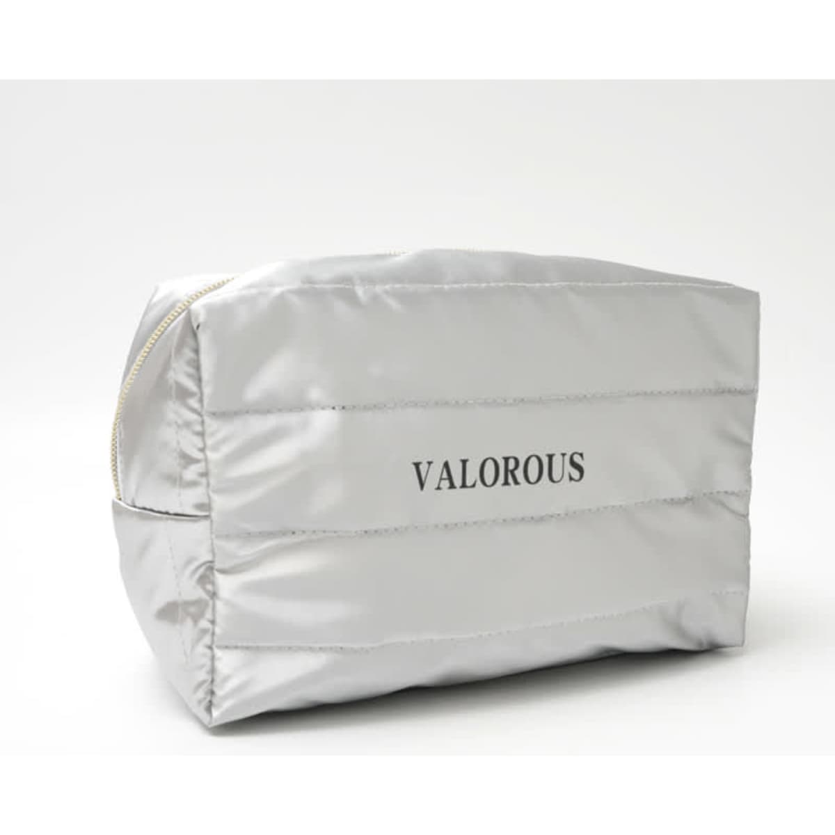 A silver quilted cosmetic bag with a zipper closure and a logo. Designed for organisation of toiletries.