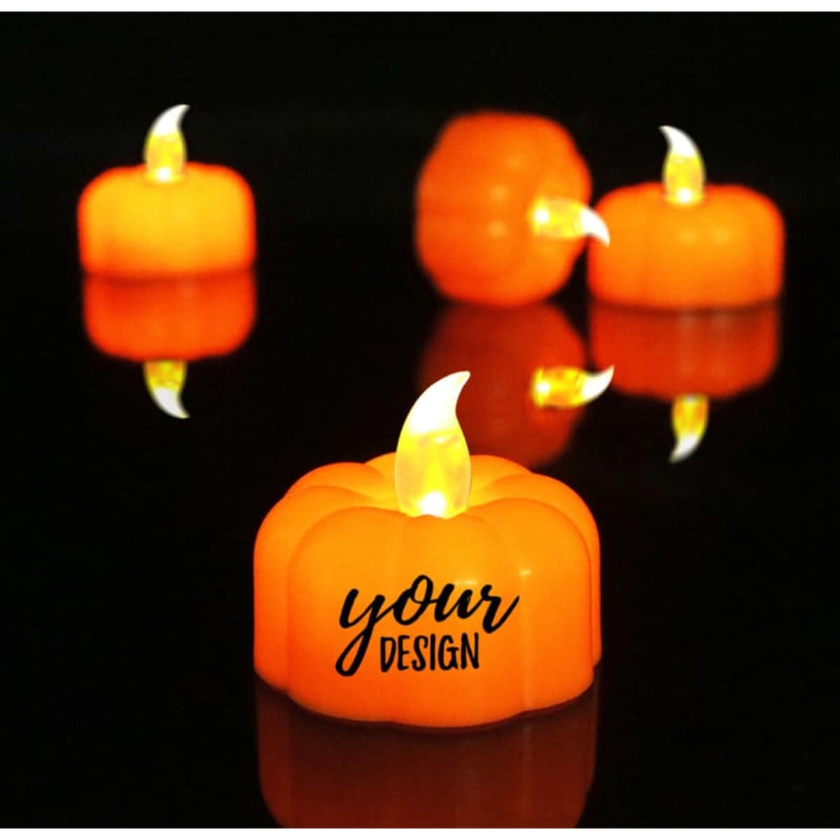 An orange pumpkin-shaped tea light with a flickering flame effect, surrounded by similar lights on a dark surface.
