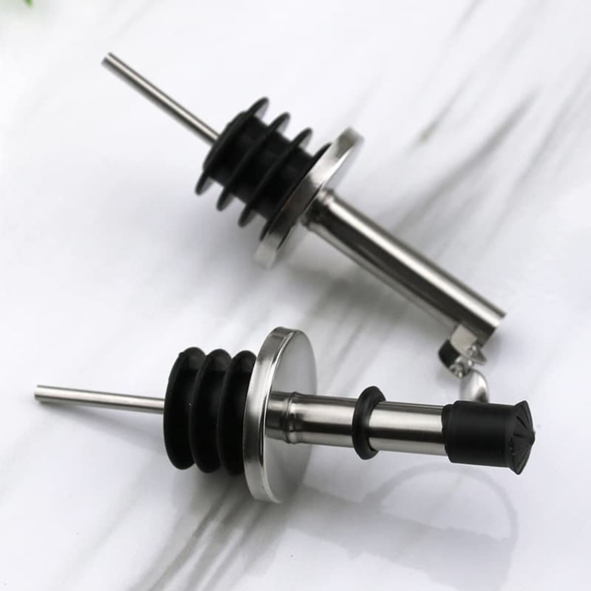 A stainless steel wine pourer spout with black rubber detailing, featuring a sleek and modern design.