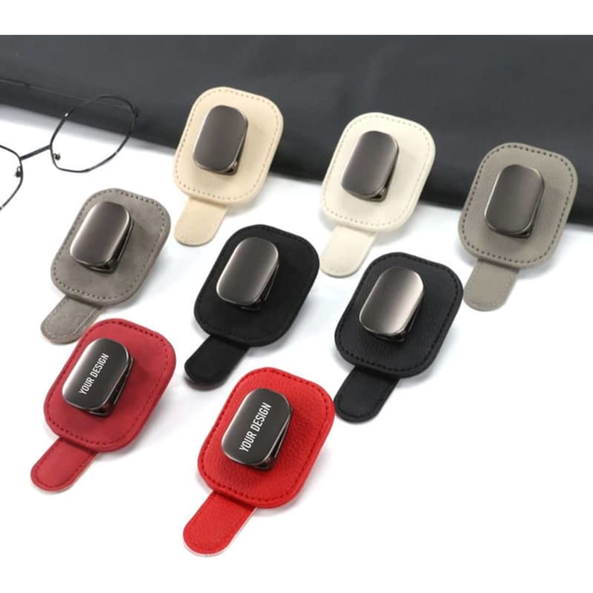 A collection of car visor sunglass holders in various colours: grey, beige, white, black, and red, each with a logo.