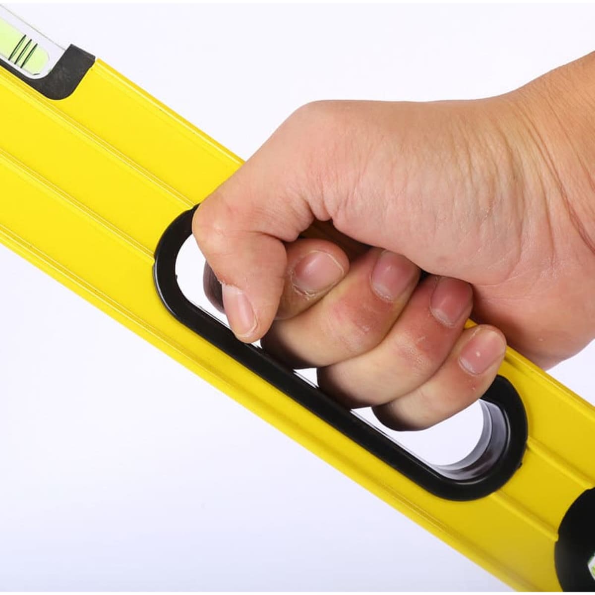 A yellow aluminium alloy spirit level held in a hand, featuring a built-in grip and vials for measurement.