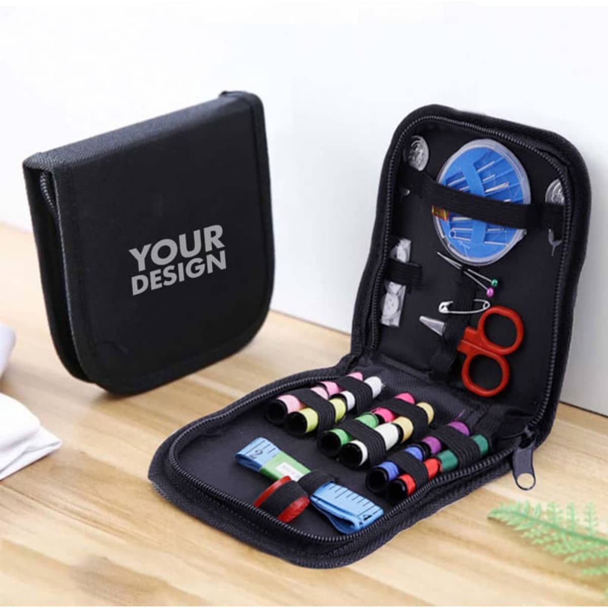 A black sewing kit featuring spools of thread, scissors, a needle threader, and other accessories in a zippered case.