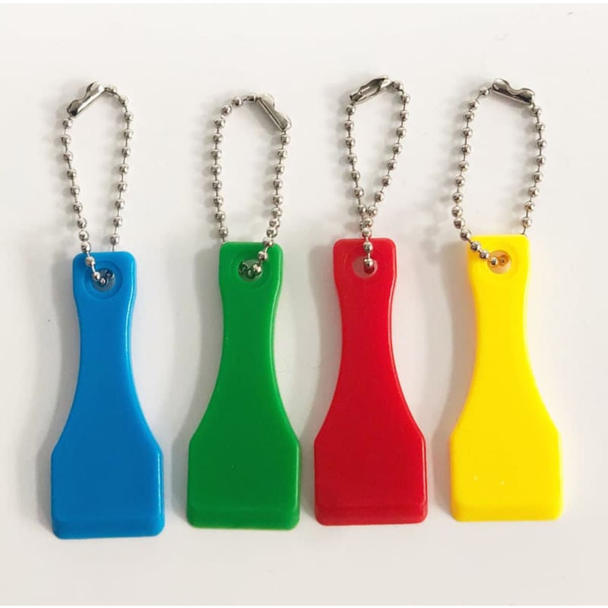 A set of four lottery scratcher keychains in blue, green, red, and yellow, attached to silver chains.