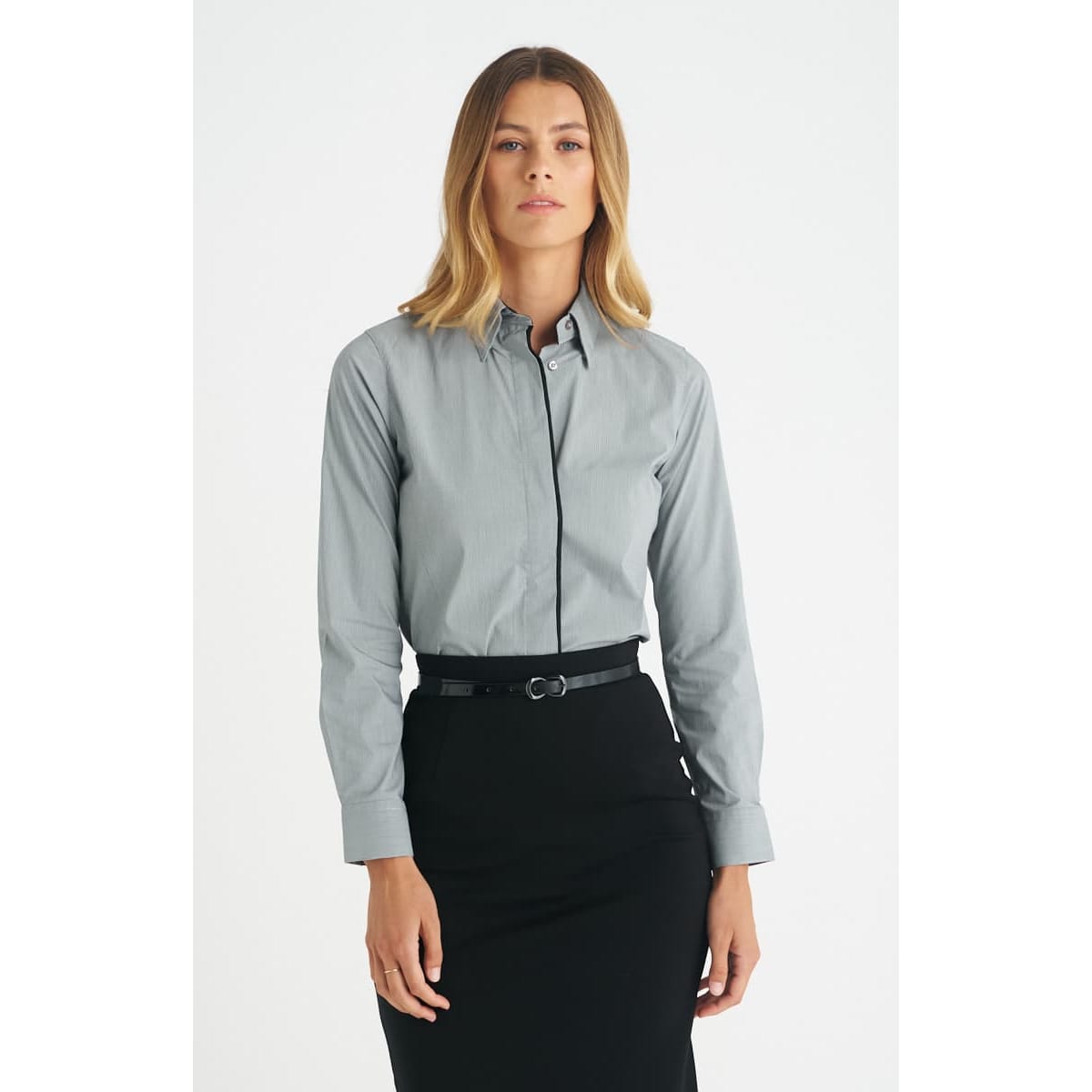 A grey ladies long sleeve button-up shirt worn with a black skirt, featuring a subtle logo.