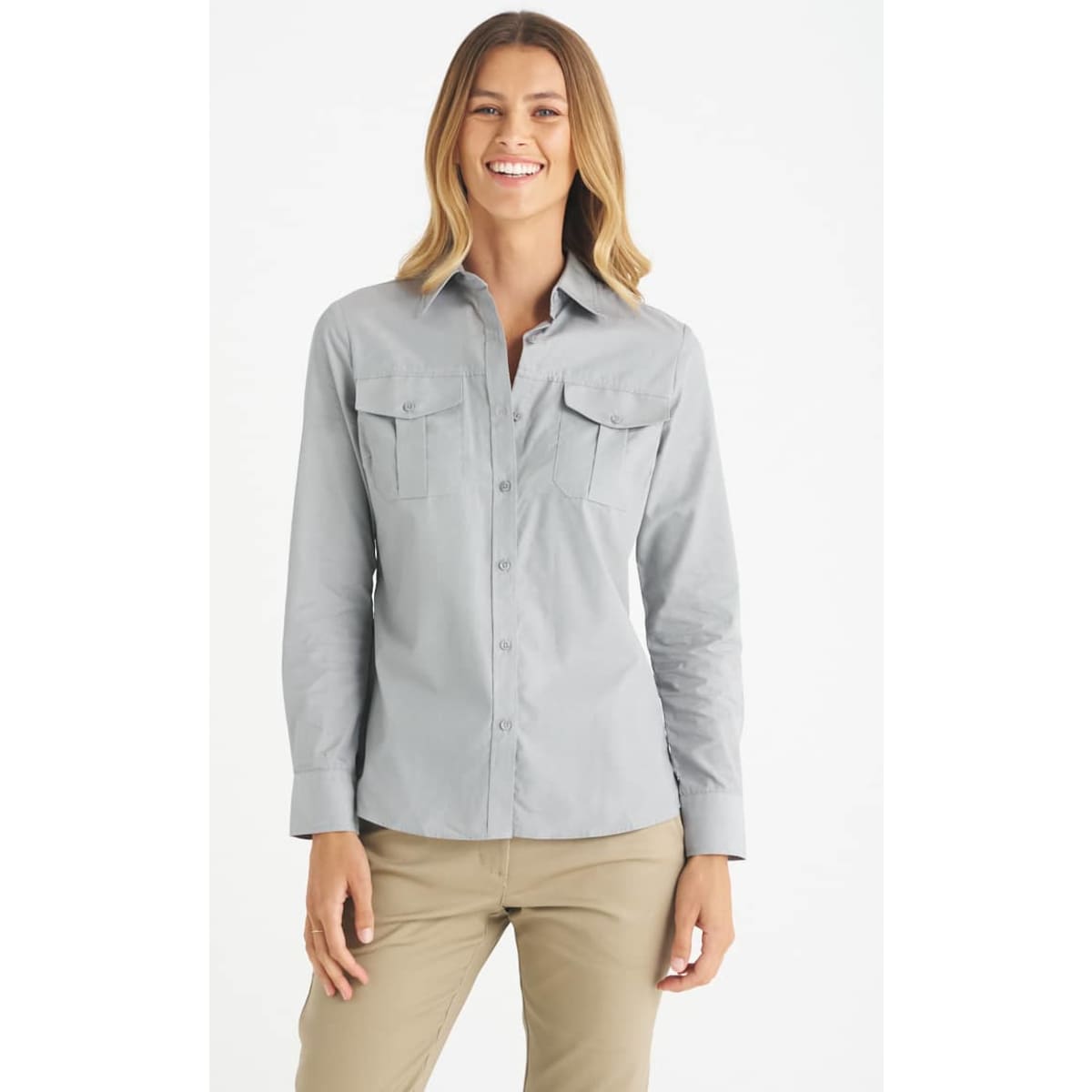 A light grey button-up shirt with two front pockets, designed for women, featured on a model.