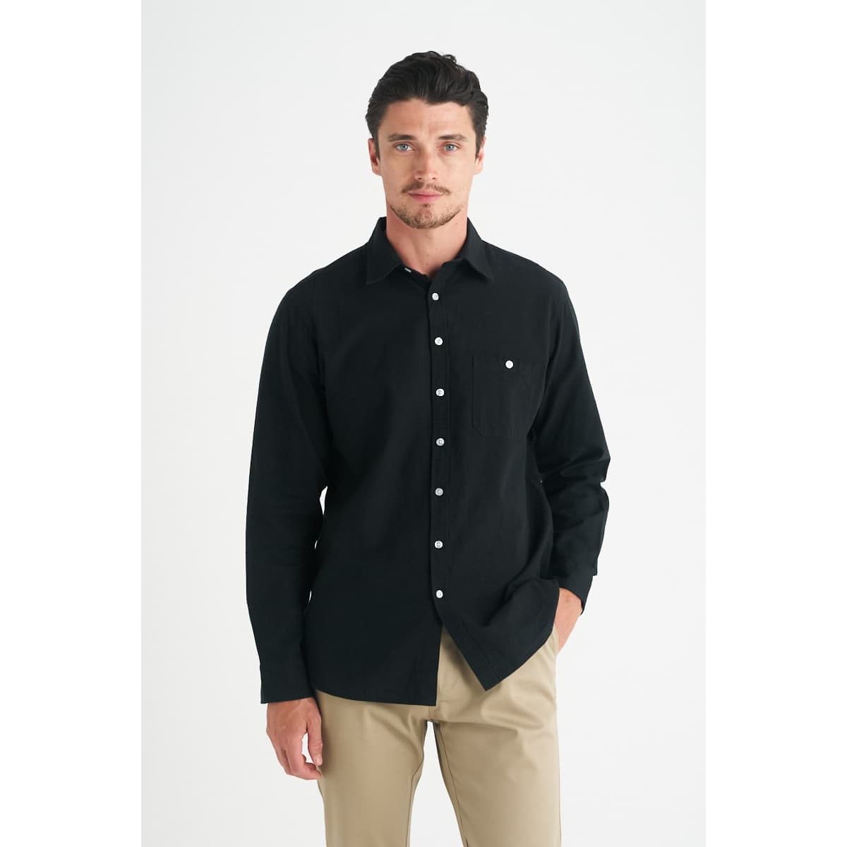A men's long sleeve button-up shirt in black, featuring a single chest pocket and a logo.