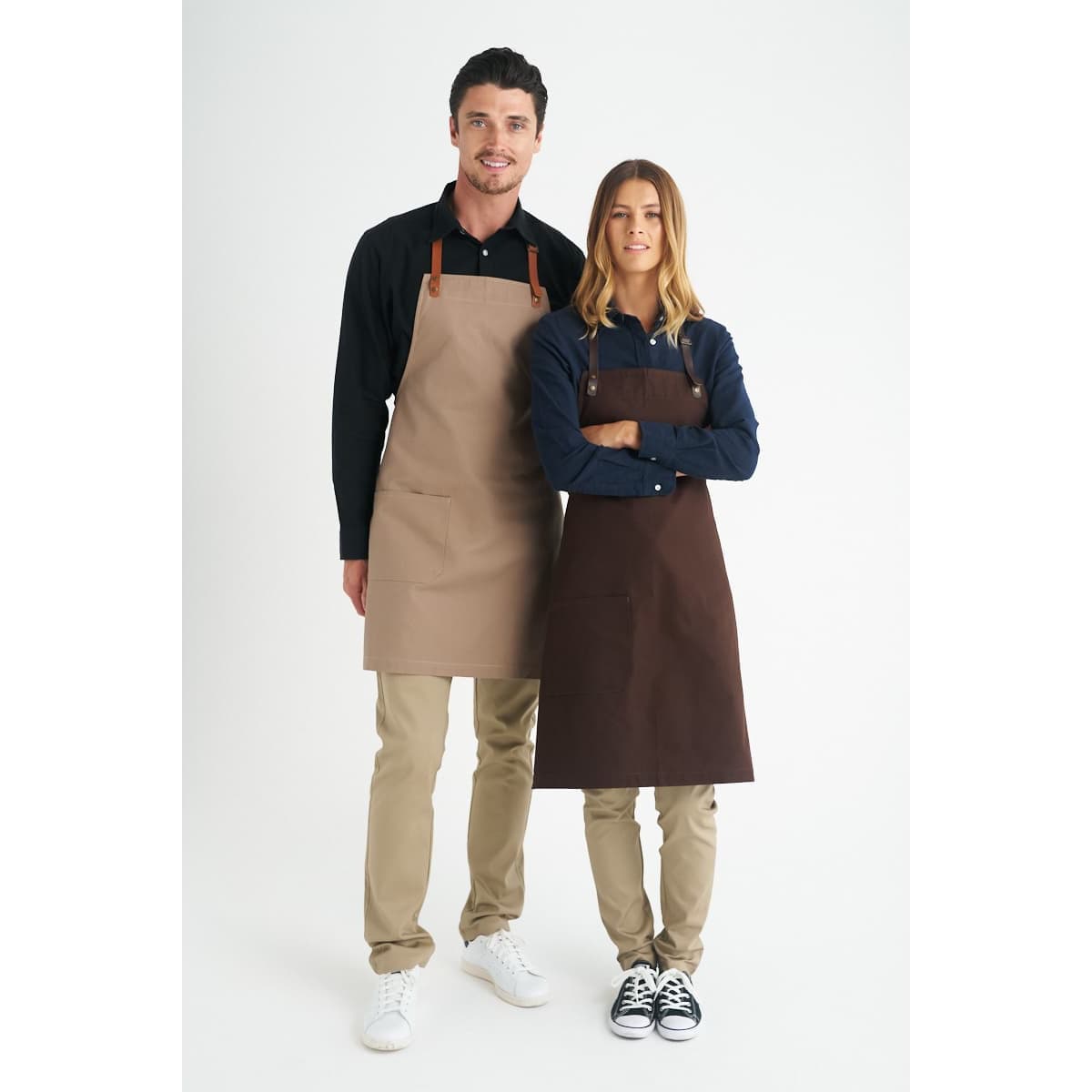 A beige and brown bib apron is displayed on two models against a white background, showcasing a logo on the product.