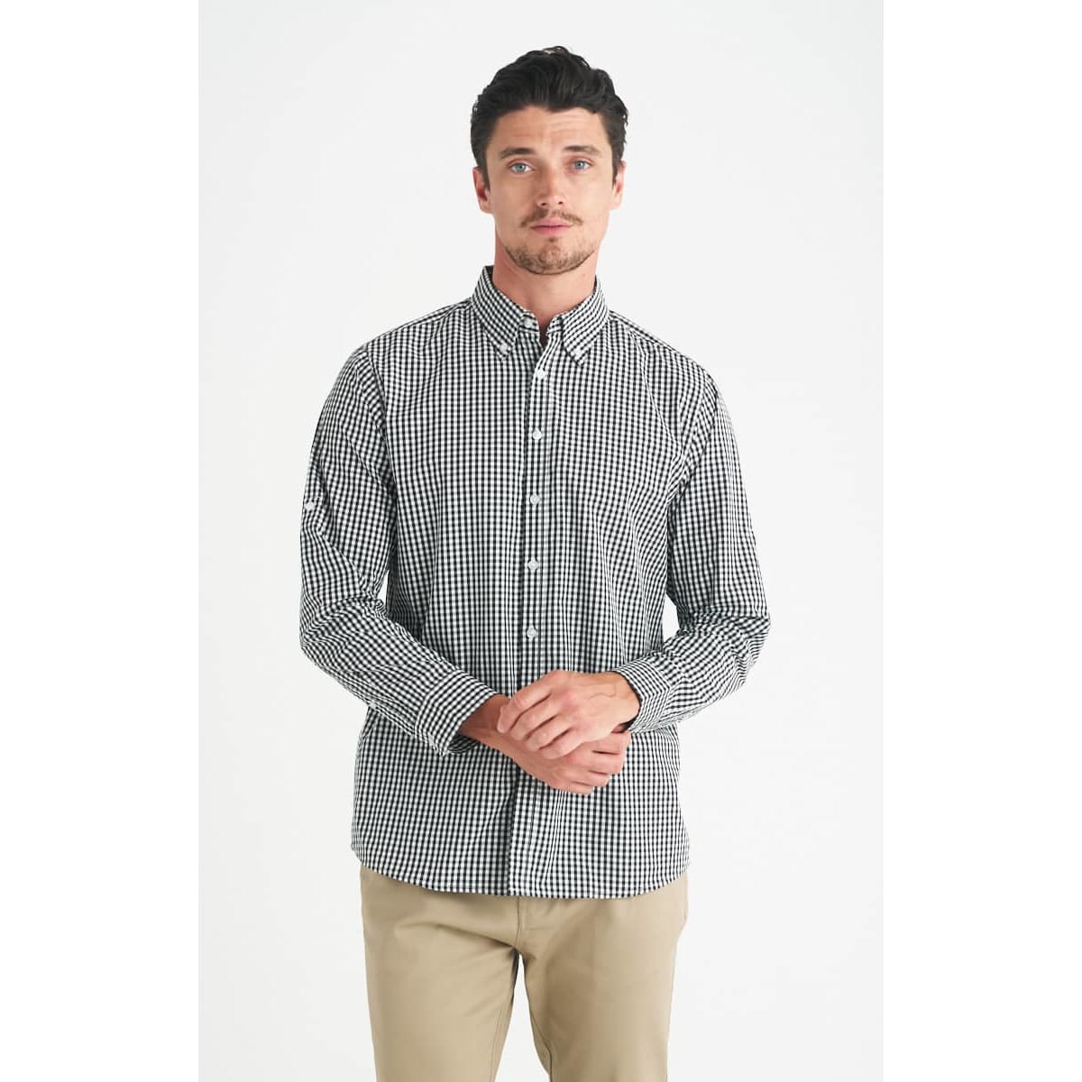 A long-sleeve, button-up shirt in a black and white gingham pattern, featuring a logo on the chest.