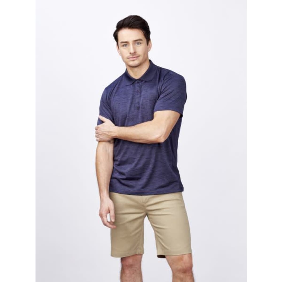 A navy blue men's polo shirt displayed on a model, featuring a logo and styled with beige shorts.