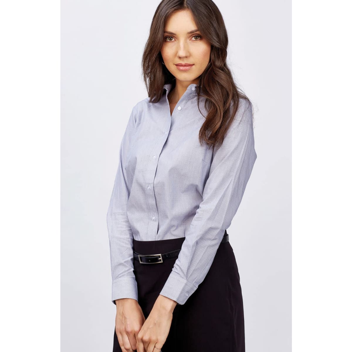 A button-up shirt in light blue, featuring long sleeves and a collar, worn by a woman with long hair.