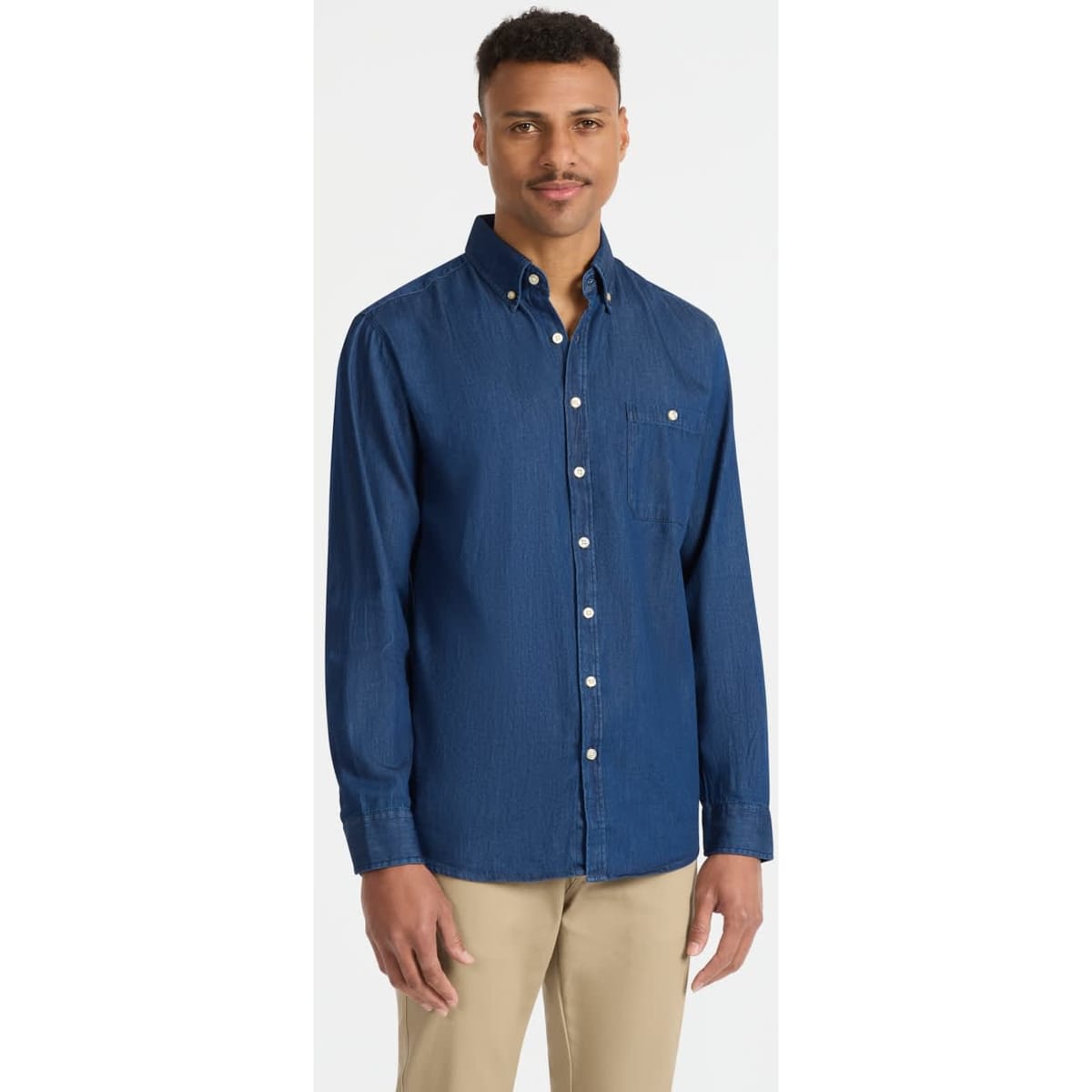 A mens long sleeve button-up shirt in a deep blue shade, featuring a chest pocket and white buttons.