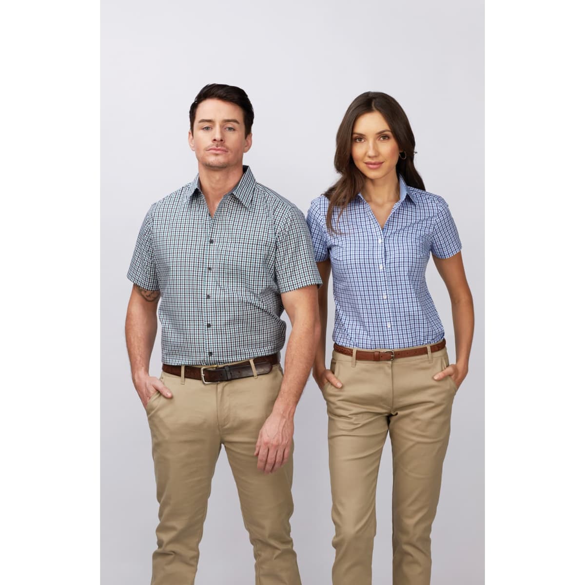 A short sleeve button-up shirt in blue and white check pattern worn by a man and woman, paired with beige trousers.