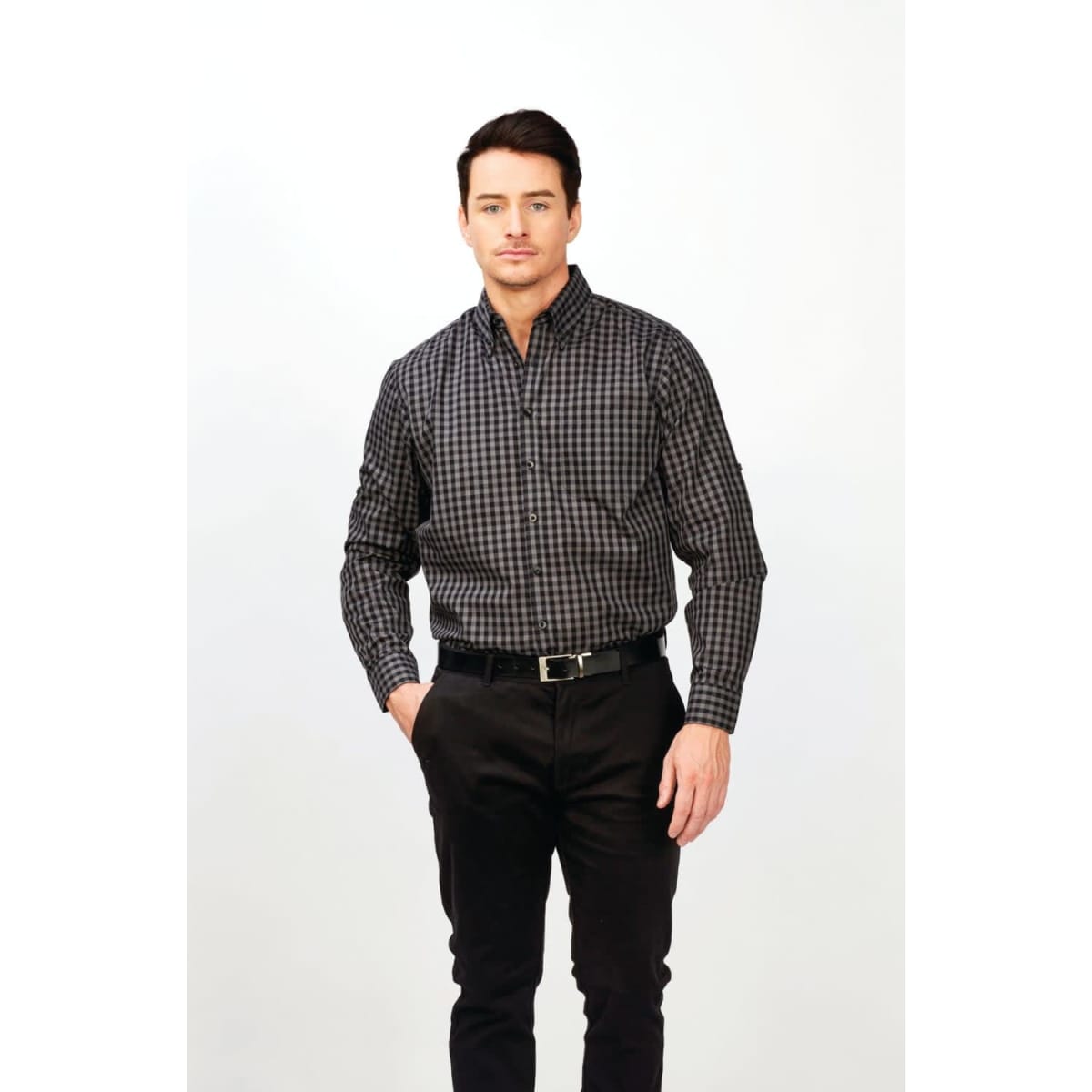 A long sleeve shirt in a black and grey checkered pattern, featuring a logo, worn by a model with dark hair.