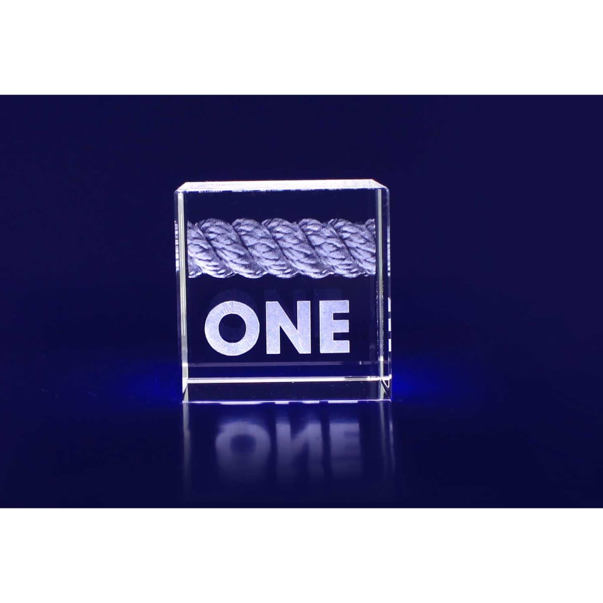 A 3D crystal cube with a rope design inside, featuring the word "ONE" in bold lettering. The cube is clear and surrounded by a deep blue background.