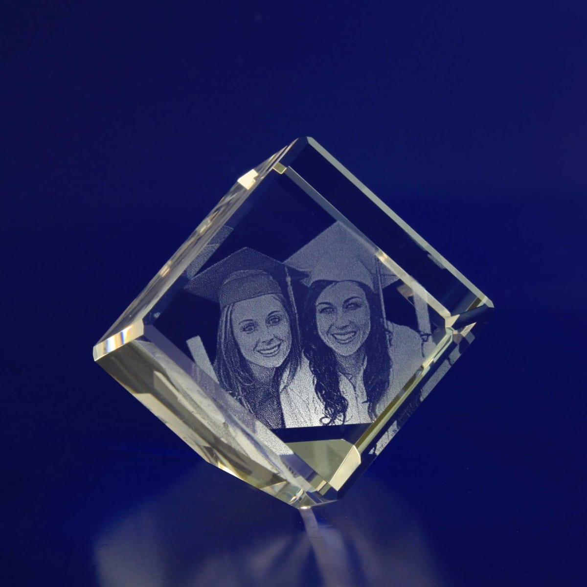 A 3D crystal diamond featuring a detailed engraved image of two smiling graduates, with a clear and luminous finish.
